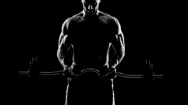 Nahaufnahme eines jungen muskulösen Mannes, der Gewichte über dunklen Rücken stemmt Stockfoto