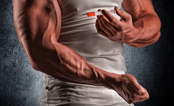 A muscular man with a syringe — Stock Photo, Image