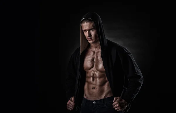 Мускулистый спортсмен после тренировок на черном фоне — стоковое фото