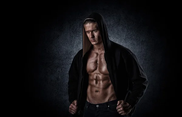 Musculoso hombre deportivo después de pesas entrenamiento sobre negro backgroun —  Fotos de Stock