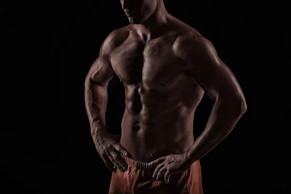 Homem atlético forte no fundo preto — Fotografia de Stock