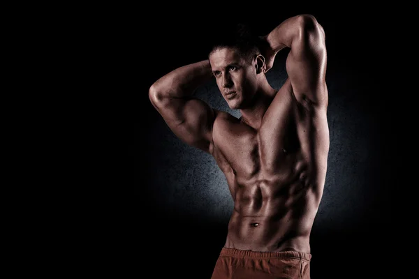A young and fit male model posing his muscles — Stock Photo, Image