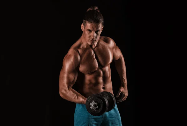 Сильный атлетичный мужчина с идеальным телом, позирующий с гантелями — стоковое фото