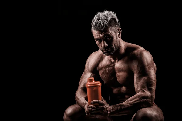 Hombre cansado descansando después del entrenamiento, sosteniendo la botella en la mano . — Foto de Stock