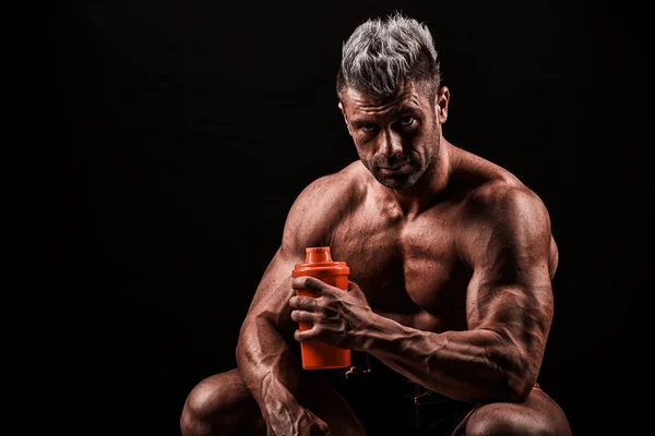 Tired man resting after training, holding bottle in hand. — Stock Photo, Image