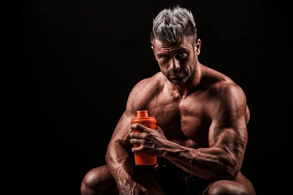 Uomo stanco che riposa dopo l'allenamento, tenendo in mano la bottiglia . — Foto Stock