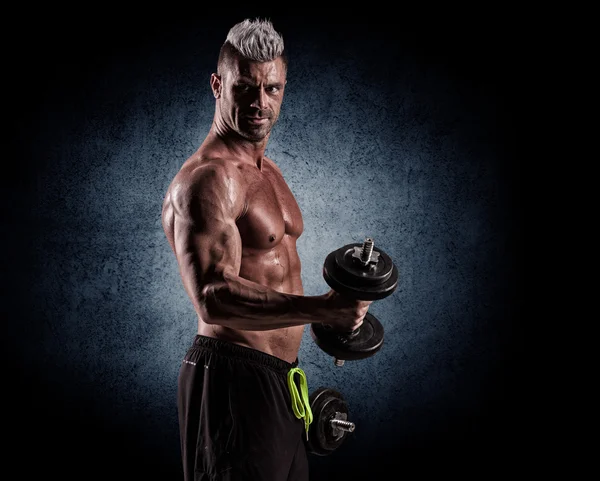 Fit muscular man exercising with dumbbell — Stock Photo, Image