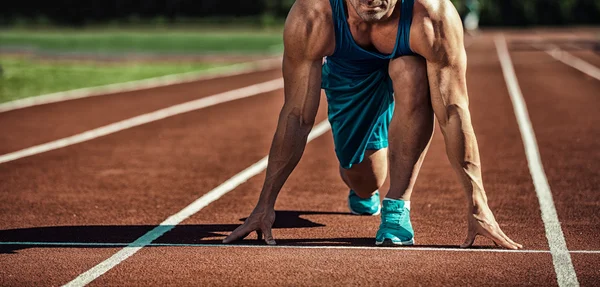 Joven atleta muscular está en el inicio de la cinta de correr en el s —  Fotos de Stock