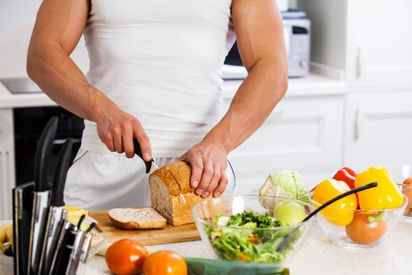 Närbild av en kock som innehar en baguette framför en bambu cutti — Stockfoto