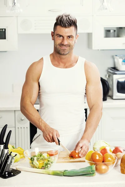 Feliz hombre guapo cocinando en la cocina en casa. —  Fotos de Stock