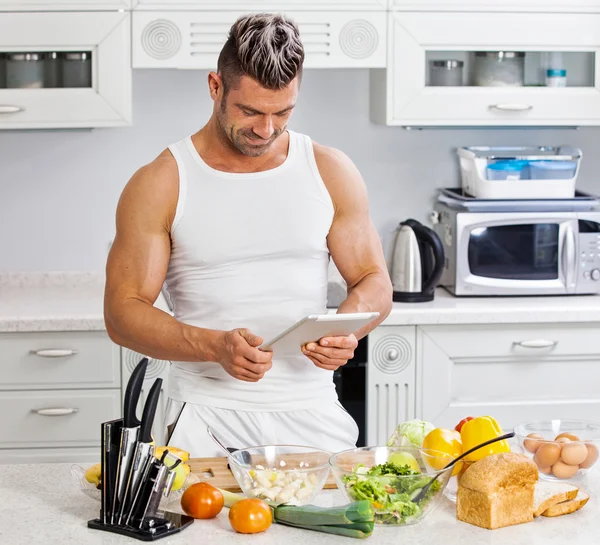 Glad stilig man matlagning i köket hemma. — Stockfoto