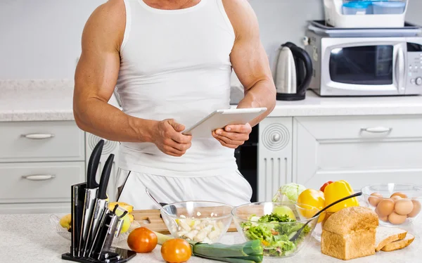 Glad stilig man matlagning i köket hemma. — Stockfoto