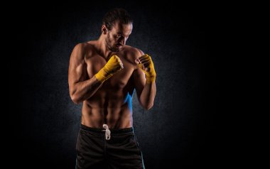 Strong muscular boxer in red boxing gloves. A man in a boxing 