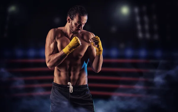 Strong muscular boxer in red boxing gloves. A man in a boxing — Stock fotografie