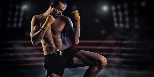 Boxeador musculoso fuerte con guantes de boxeo rojos. Un hombre en un boxeo —  Fotos de Stock