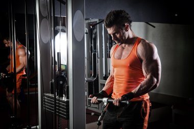 Spor salonunda ağırlık kaldıran genç bir vücut geliştirici..