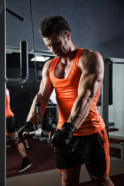 Giovane bodybuilder adulto che fa sollevamento pesi in palestra. — Foto Stock