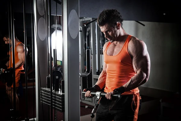 Spor salonunda ağırlık kaldıran genç bir vücut geliştirici..