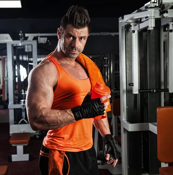 Kas koyu arka planda eğitim genç vücut geliştirmeci arkası