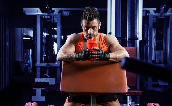 Przystojny młody muskularny mężczyzna pije białko w siłowni — Zdjęcie stockowe