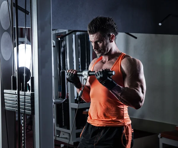 Culturista adulto joven haciendo levantamiento de pesas en el gimnasio. —  Fotos de Stock