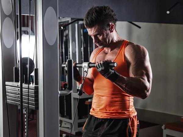 Jonge volwassen bodybuilder doet gewicht tillen in de sportschool. — Stockfoto