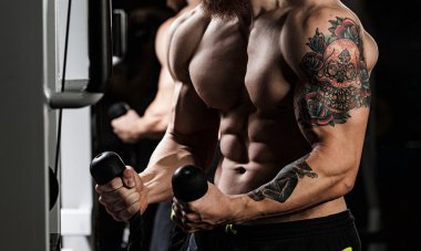 Yakışıklı genç kaslı sporcu egzersiz halter ile yürütmek