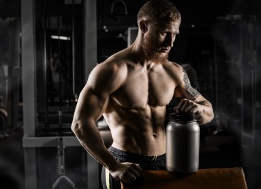 Güçlü adam - bir spor salonunda dumbbells ile vücut geliştirmeci zekâ egzersiz