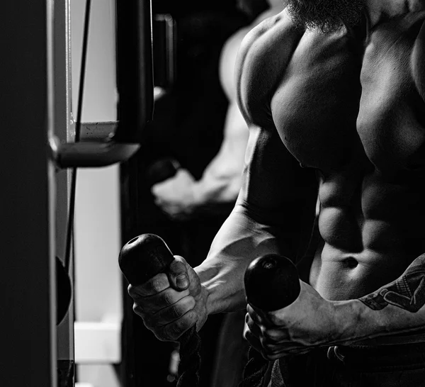 Guapo joven deportista muscular ejecutar ejercicio con mancuerna — Foto de Stock