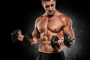 Kaslı vücut geliştirmeci adam egzersizleri izole dumbbells ile yapıyor