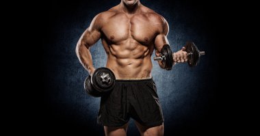 Vücut geliştirmeci duvardan etmek ile omuz egzersizleri yapıyor.