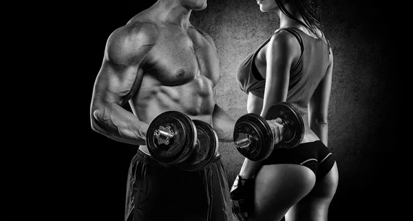 Athletic man and woman with a dumbbells — Stock Photo, Image