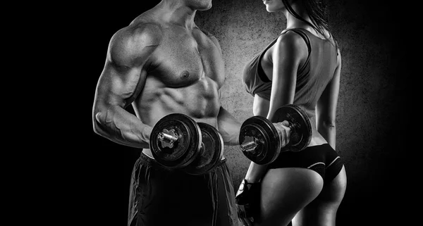 atletik erkek ve kadın bir dumbbells ile