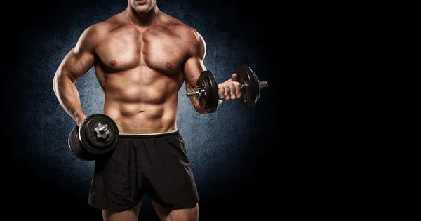 Handsome man with big muscles, posing at the camera in the gym — Stock Photo, Image