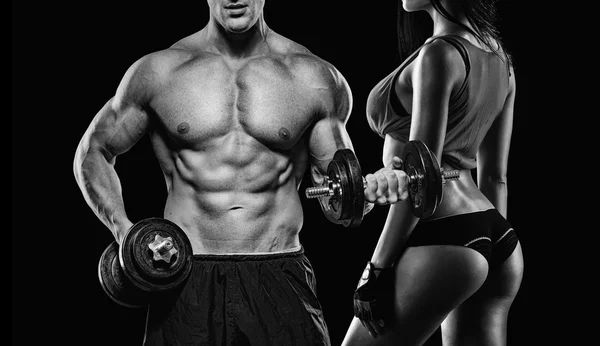 Athletic man and woman with a dumbbells — Stock Photo, Image