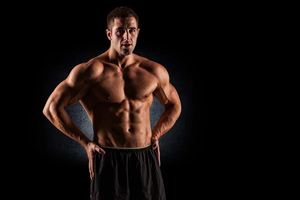 Крупним планом м'язистий молодий чоловік піднімає ваги — стокове фото