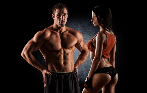 Fitness couple against black background — Stock Photo, Image