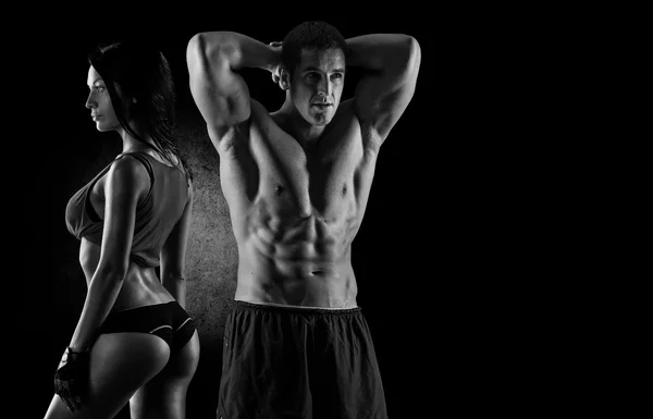 Fitness couple against black background — Stock Photo, Image