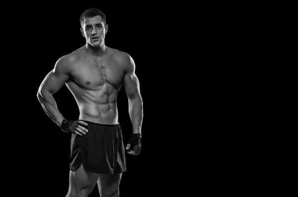 Retrato de um fisiculturista muscular bonito posando sobre ba preto — Fotografia de Stock