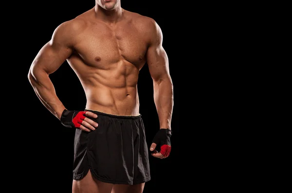 Retrato de um fisiculturista muscular bonito posando sobre ba preto — Fotografia de Stock