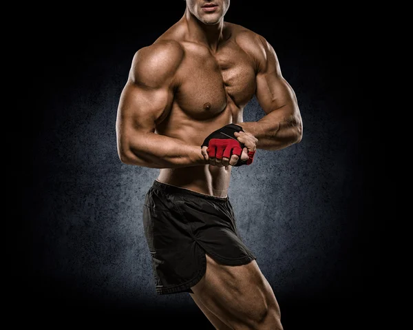 Shirtless bodybuilder holding dumbell and showing his muscular a — Stock Photo, Image