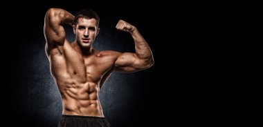 kaslı vücut geliştirmeci biri dumbbells ile yapıyor