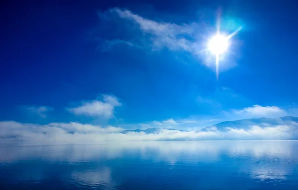 太陽と地平線上に雲と水の風景 — ストック写真