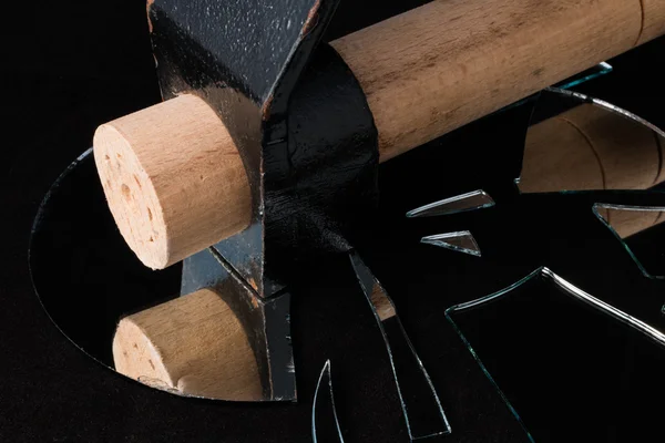 Hammer broken mirror pieces on a black background — Stock Photo, Image