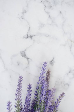 Lavanta çiçekleri mermer bir arka planda yatıyor. Yazıtlar için bir yer var.