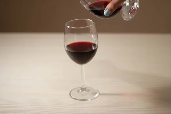 Due bicchieri di vino rosso. La ragazza sta per versare il vino da un bicchiere all'altro — Foto Stock