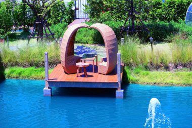 Bahçedeki aşıklar için suyun üzerinde romantik bir koltuk..