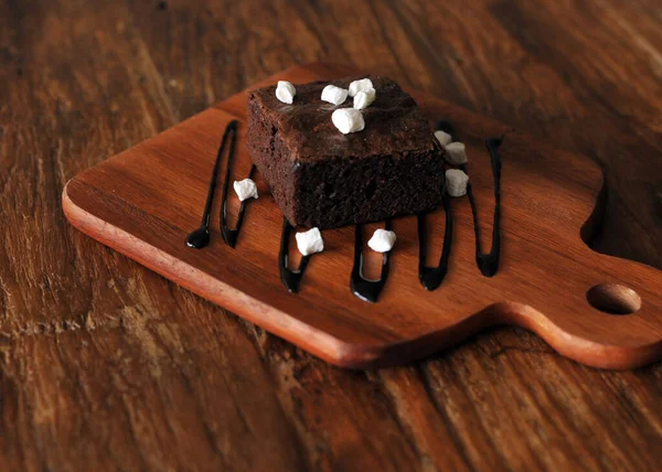 自家製チョコレートブラウニートッピングマシュマロ付き木製の背景 — ストック写真