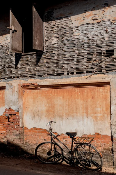 Τοίχο από τούβλα ραγισμένα και παλιό σκουριασμένο εκλεκτής ποιότητας ποδηλάτων — Φωτογραφία Αρχείου