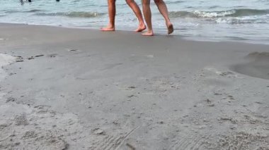 Erkek ve kadın kumsalda yürüyor